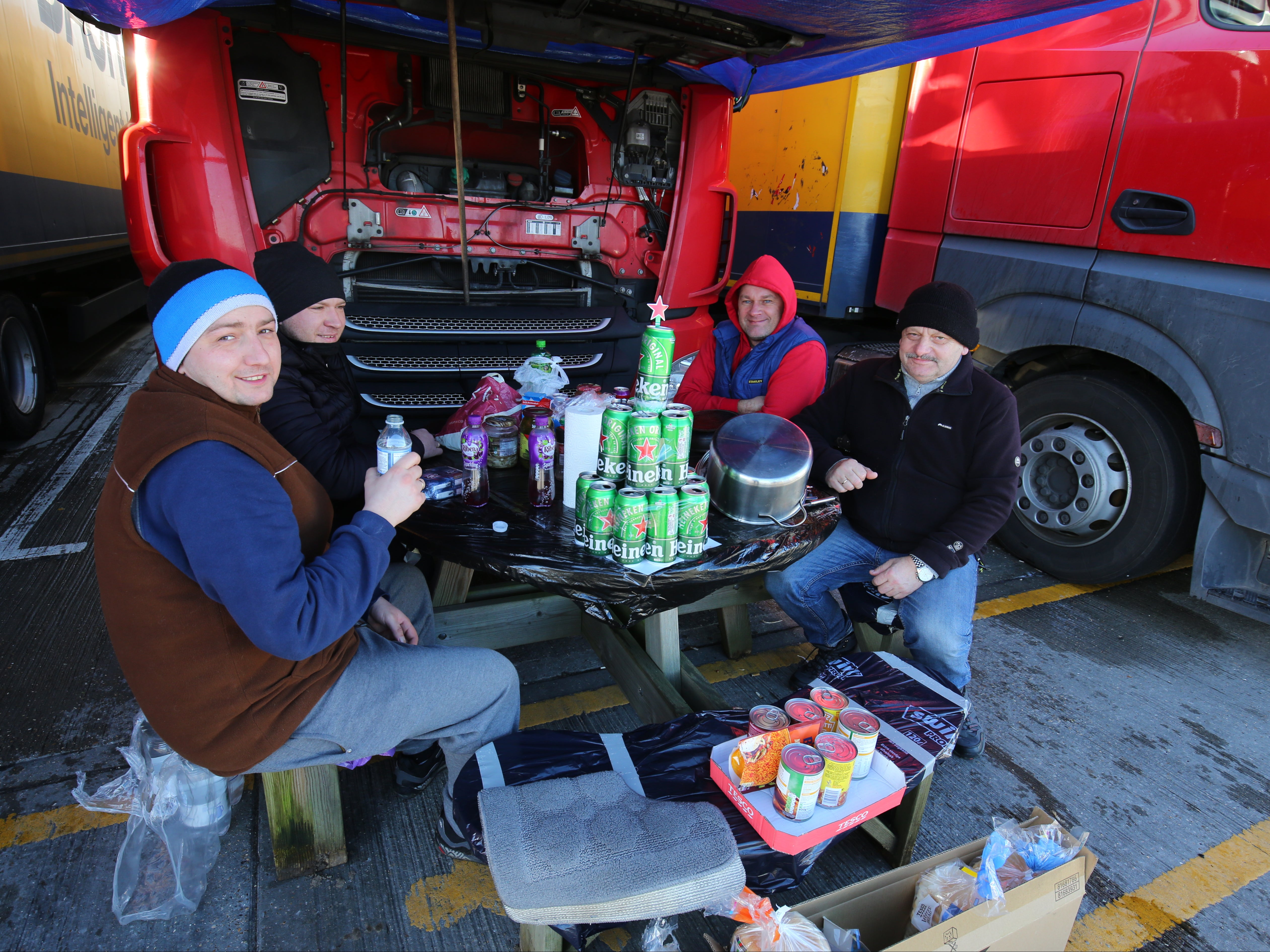 Polish lorry drivers, with a makeshift Christmas tree fashioned out of empty Heineken cans, share Christmas Day food and drinks at a truck stop near Folkestone, Kent