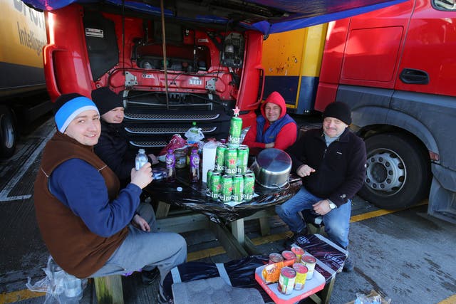 <p>Polish lorry drivers, with a makeshift Christmas tree fashioned out of empty Heineken cans, share Christmas Day food and drinks at a truck stop near Folkestone, Kent</p>