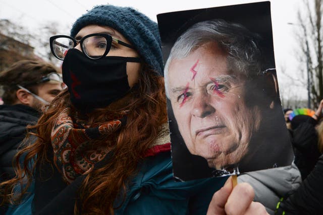 Anti-government protesters hold up images of the ruling party leader, Jaroslaw Kaczynski, in Warsaw, earlier this month (AP Photo/Czarek Sokolowski)