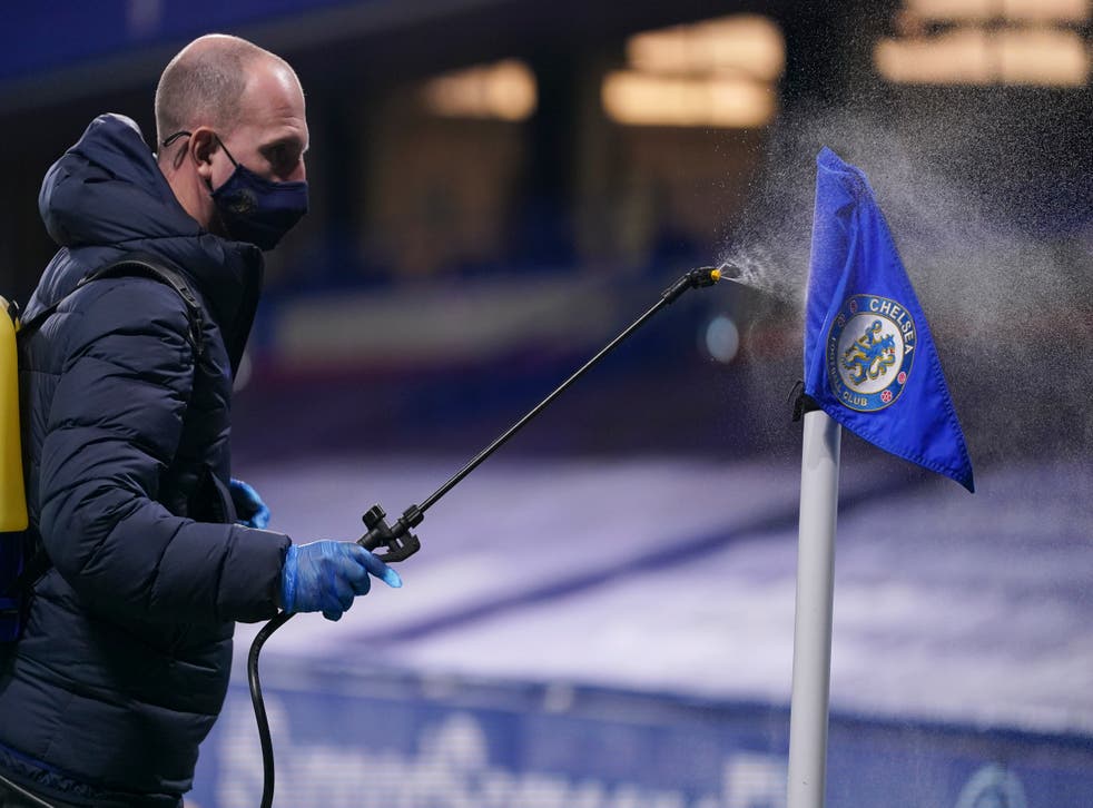 <p>Un encargado rocía desinfectante sobre una bandera de esquina durante una pausa en un partido de la Liga Premier inglesa entre Chelsea y West Ham.</p>