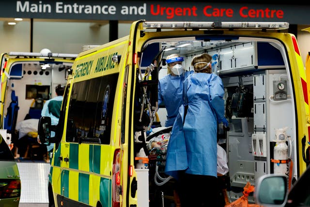 <p>Paramedics prepare to remove a patient from an ambulance as a new strain of coronavirus causes an upsurge in cases</p>