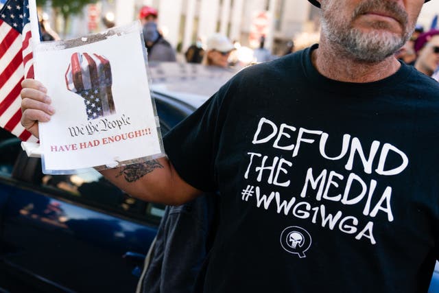 <p>File Image: A man wearing a ‘Defund the Media’ QAnon shirt is seen at a “Stop the Steal” rally against the results of the U.S. Presidential election outside the Georgia State Capitol on November 18, 2020 in Atlanta, Georgia</p>