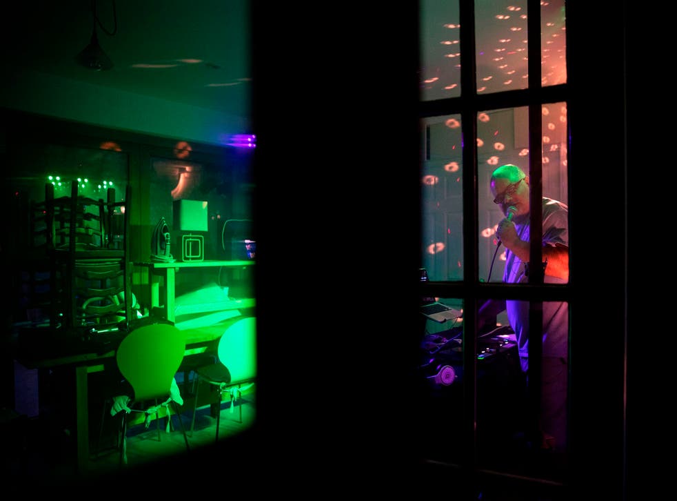 Warren Parsons, 54, DJs a music set including lighting, glitter ball and smoke machine broadcast from his kitchen in Hartley Wintney, a village 45 miles southwest of London late on May 23, 2020 during the nationwide lockdown
