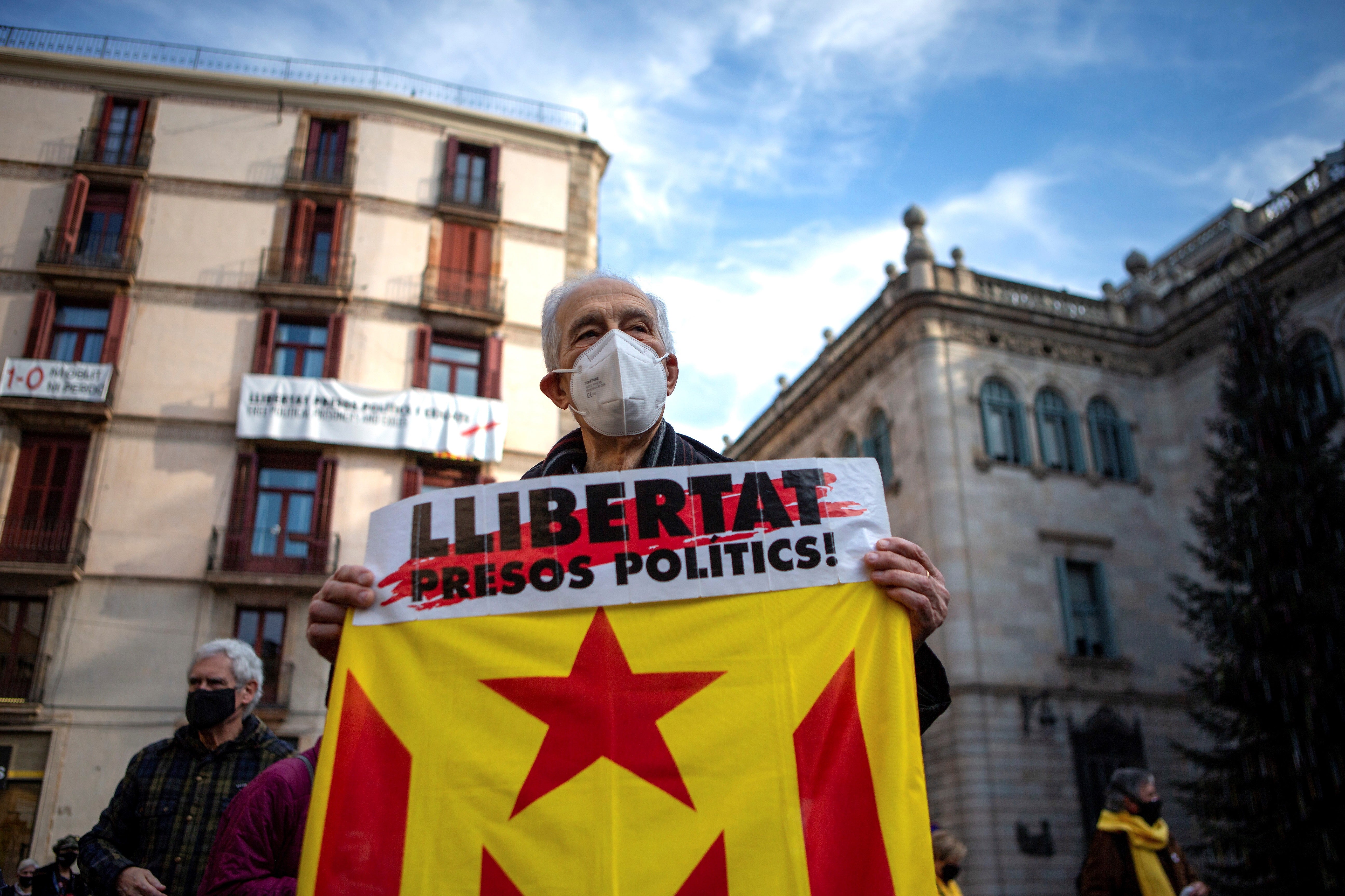 A man with a banner reading ‘Freedom for political prisoners’ in Barcelona earlier this month (EPA/ENRIC FONTCUBERTA)