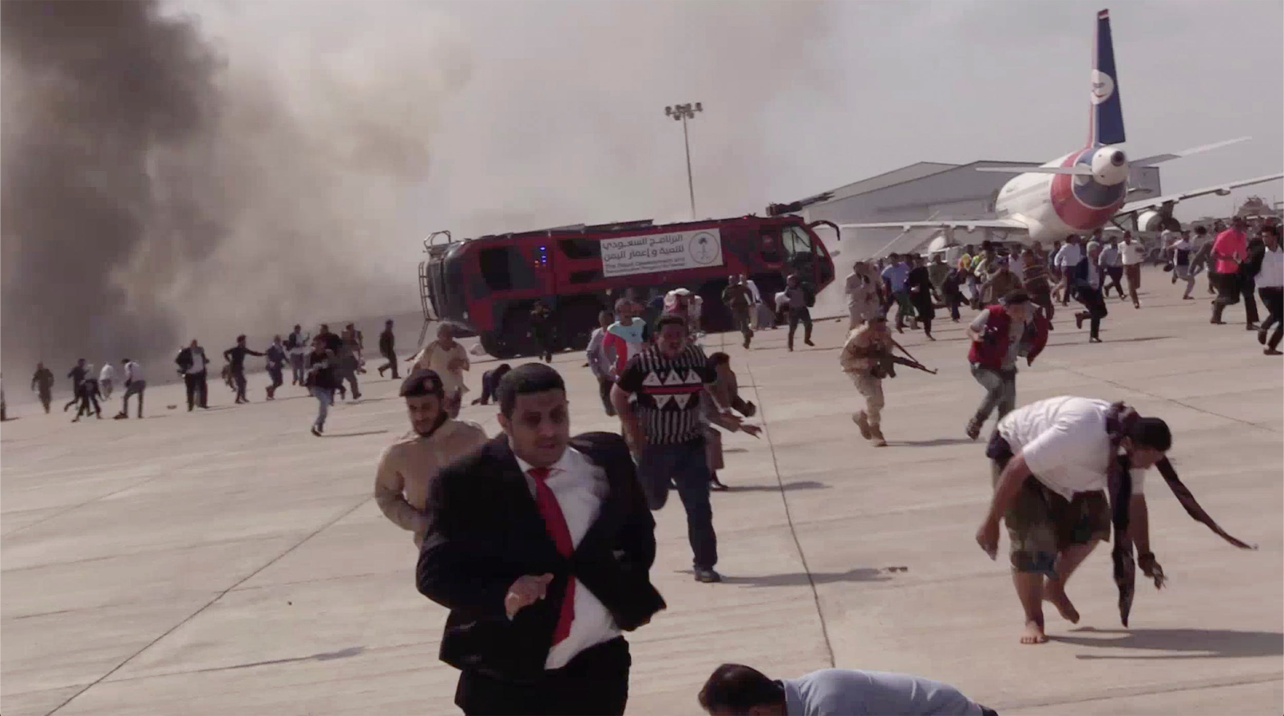 People run following an explosion at the airport in Aden