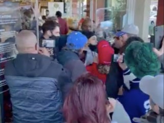 <p>A video captured by a bystander shows a crowd of maskless people pushing to get into a store</p>