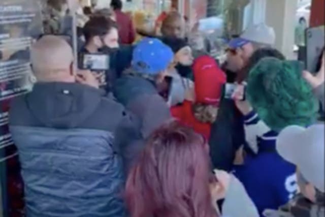 <p>A video captured by a bystander shows a crowd of maskless people pushing to get into a store</p>