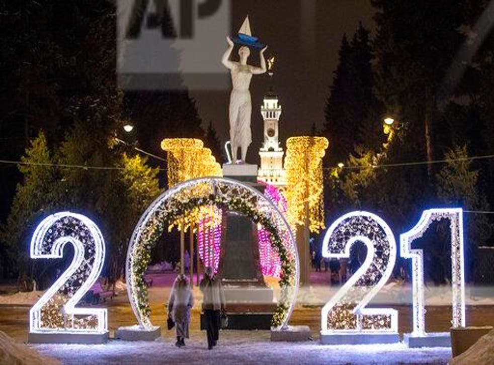 <p>People pass an installation to celebrate New Year in Moscow, Russia</p>