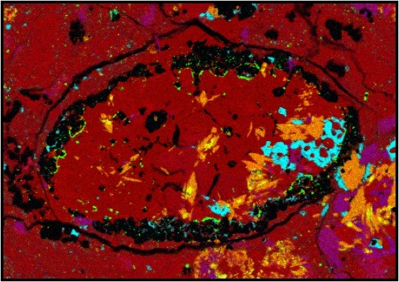 This false-color micrograph of the meteoroid sample shows the unexpected amphibole crystals identified in orange