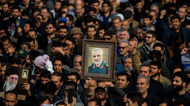 <p>Demonstrators hold up an image of Qassem Soleimani following his death</p>