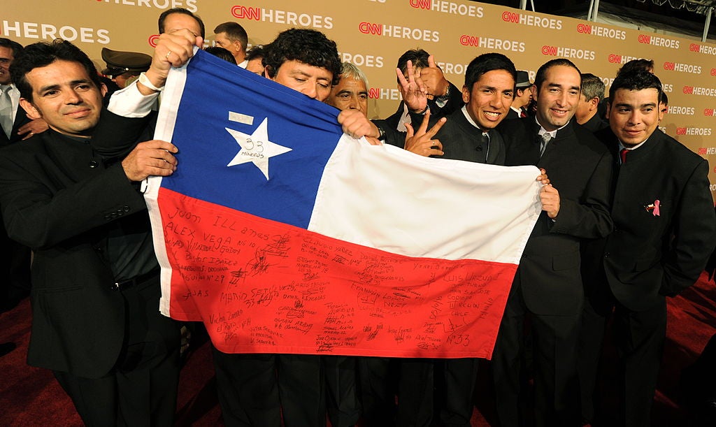 The rescued Chilean miners pose with their national flag in 2010