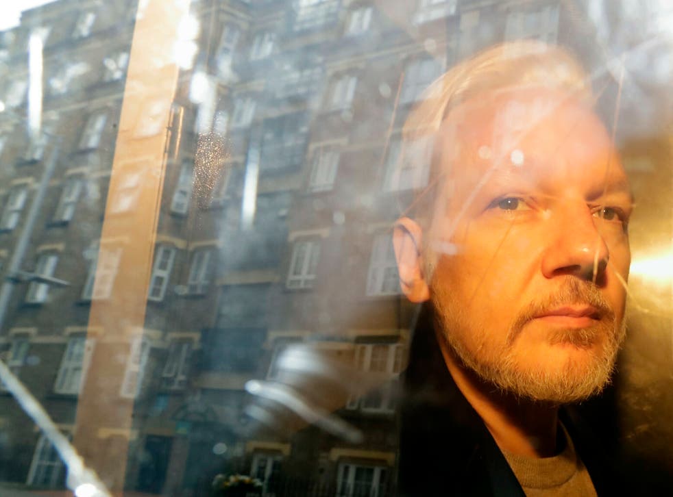 <p>ARCHIVO - En esta fotografía del miércoles 1 de mayo de 2019 se reflejan unos edificios en la ventana mientras el fundador de WikiLeaks, Julian Assange, se aleja de la corte en la que compareció por cargos de espionaje en Londres. </p>