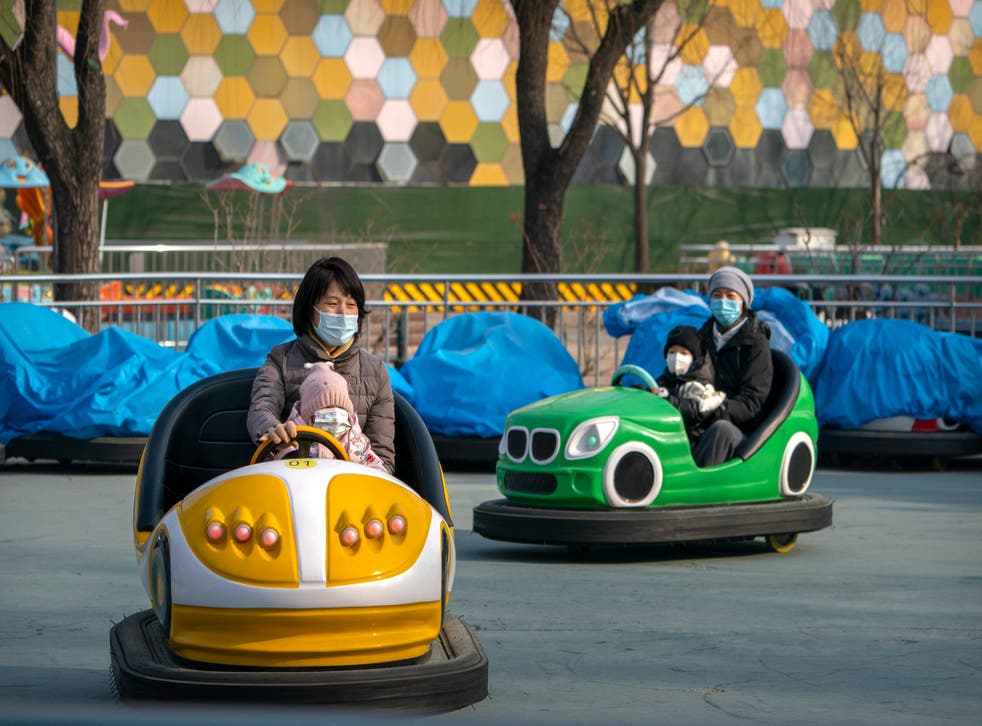 <p>Personas con mascarillas para impedir la propagación del coronavirus se divierten en cochecitos en un parque público en Beijing, el sábado 2 de enero de 2021. </p>