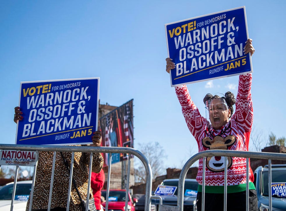 Retired Army Veteran Lisa Strange (right) cheers as Georgia U.S. Democrat Senate candidate Jon Ossoff finishes a speech during a car rally in Columbus, Georgia