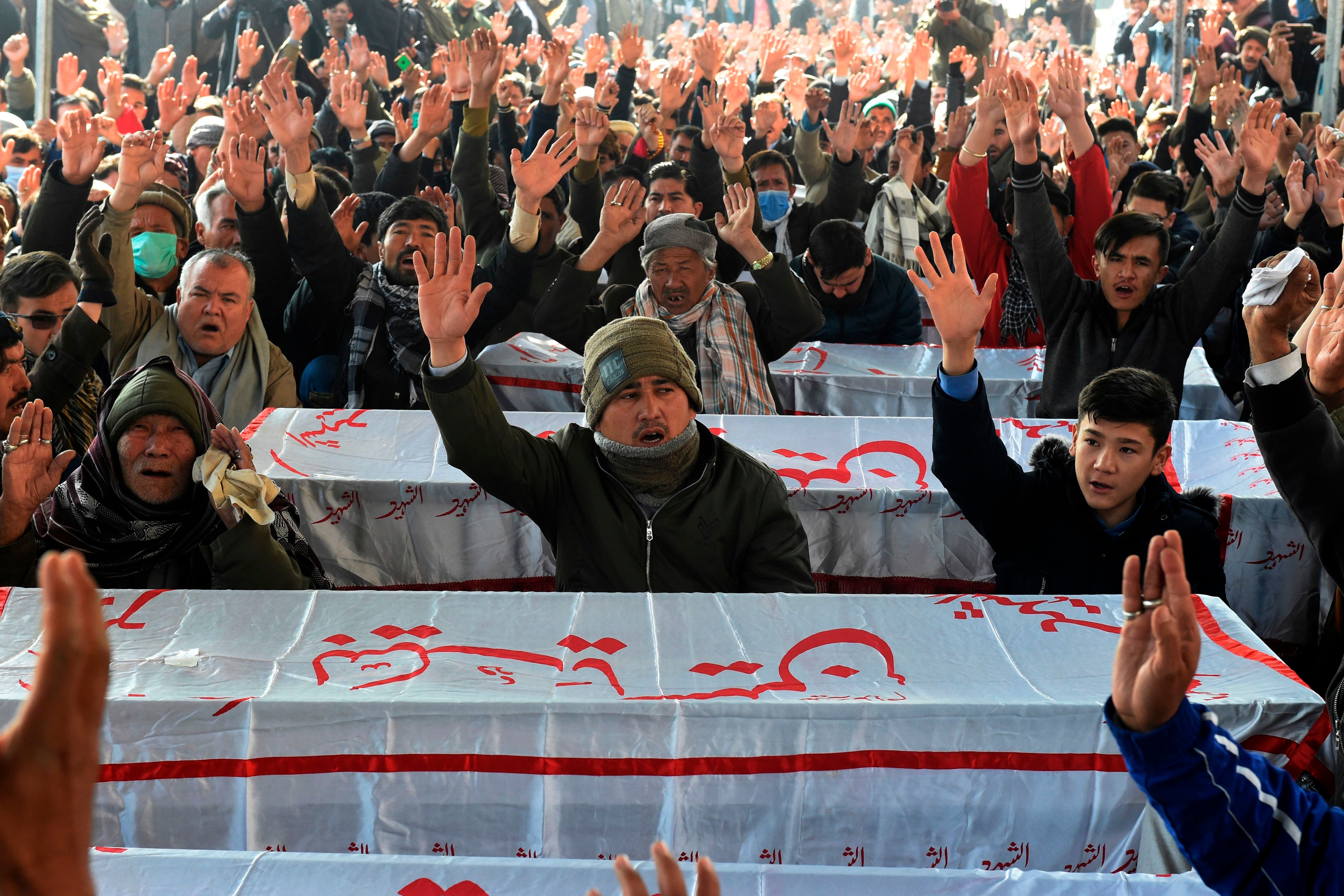 Mourners from Shiite Hazara community chant slogans near the coffins of the miners who were killed in an attack by gunmen in the mountainous Machh area, during a sit-in protest at the eastern bypass, on the outskits of Quetta on January 4, 2021.