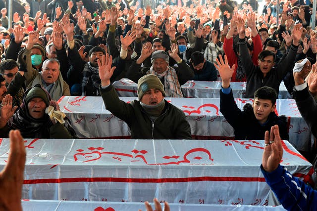 <p>Mourners from Shiite Hazara community chant slogans near the coffins of the miners who were killed in an attack by gunmen in the mountainous Machh area, during a sit-in protest at the eastern bypass, on the outskits of Quetta on January 4, 2021.</p>