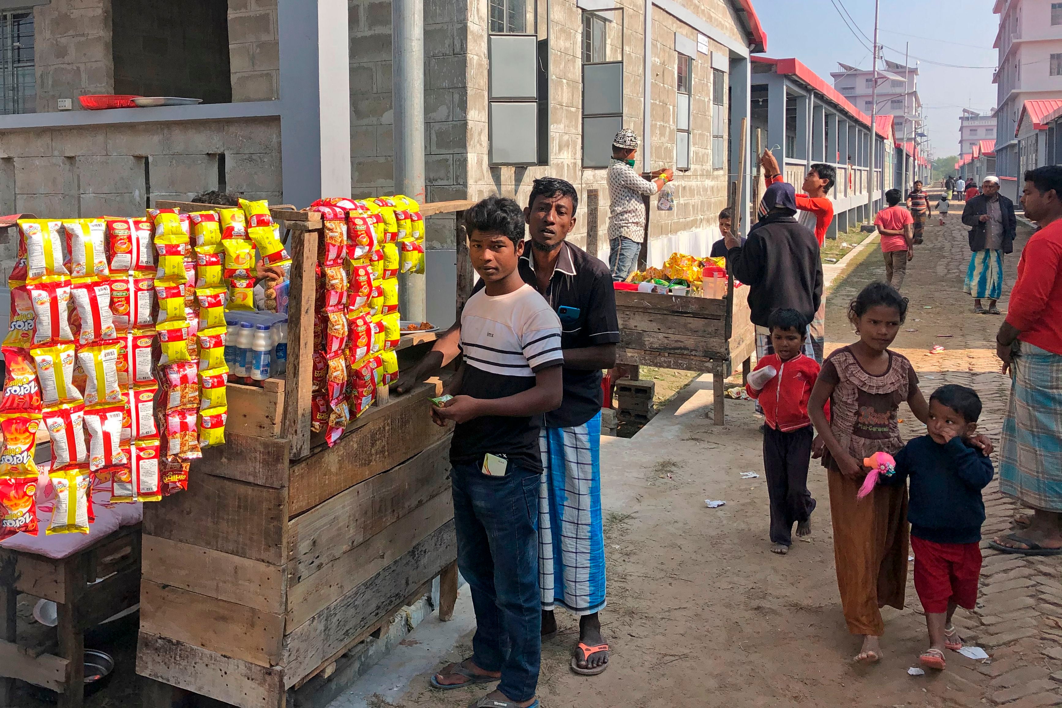 Rohingya refugees are seen next to food stalls