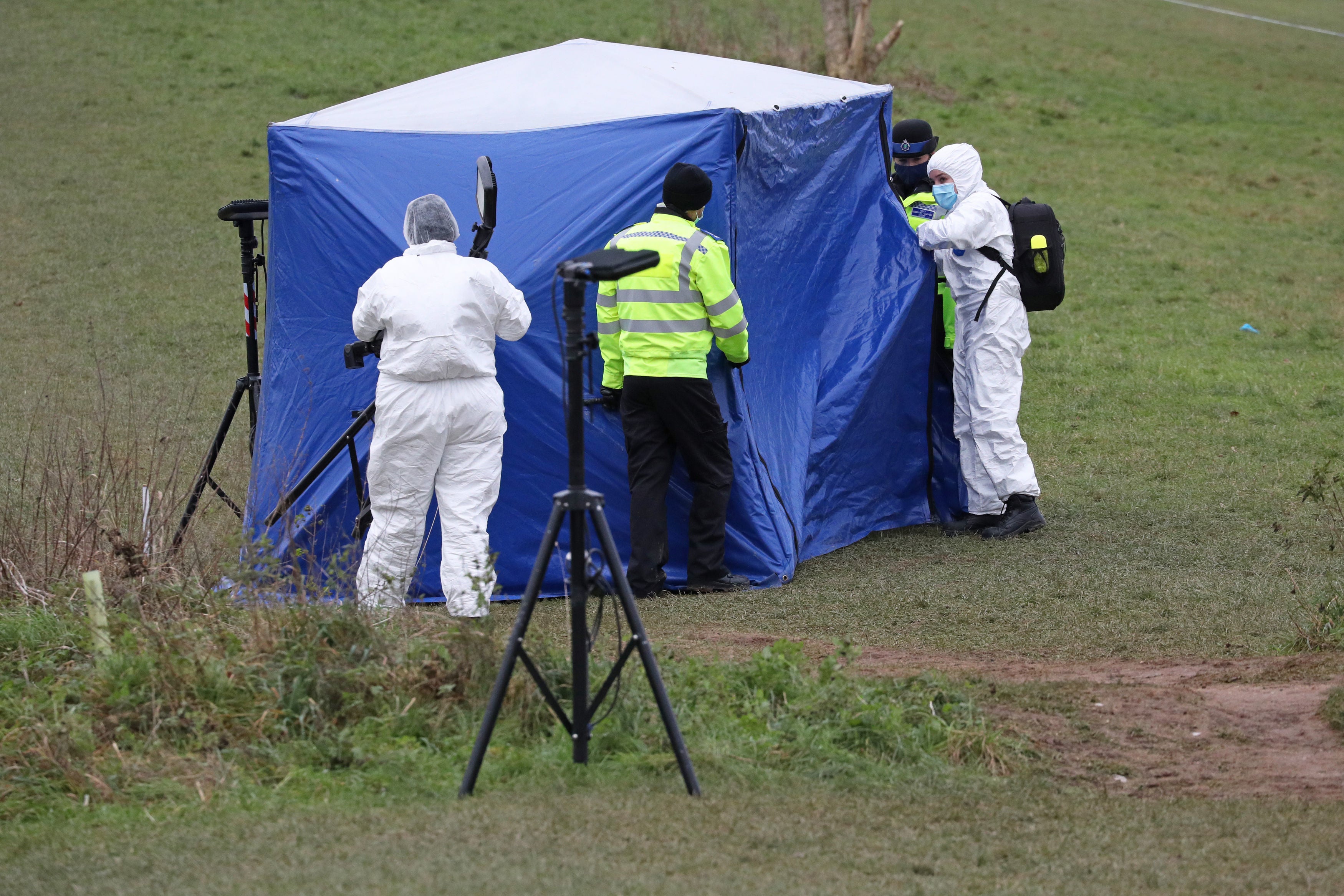 Forensic officers at a tent in Bugs Bottom field in Emmer Green, Reading, where a 13-year-old boy died after being stabbed