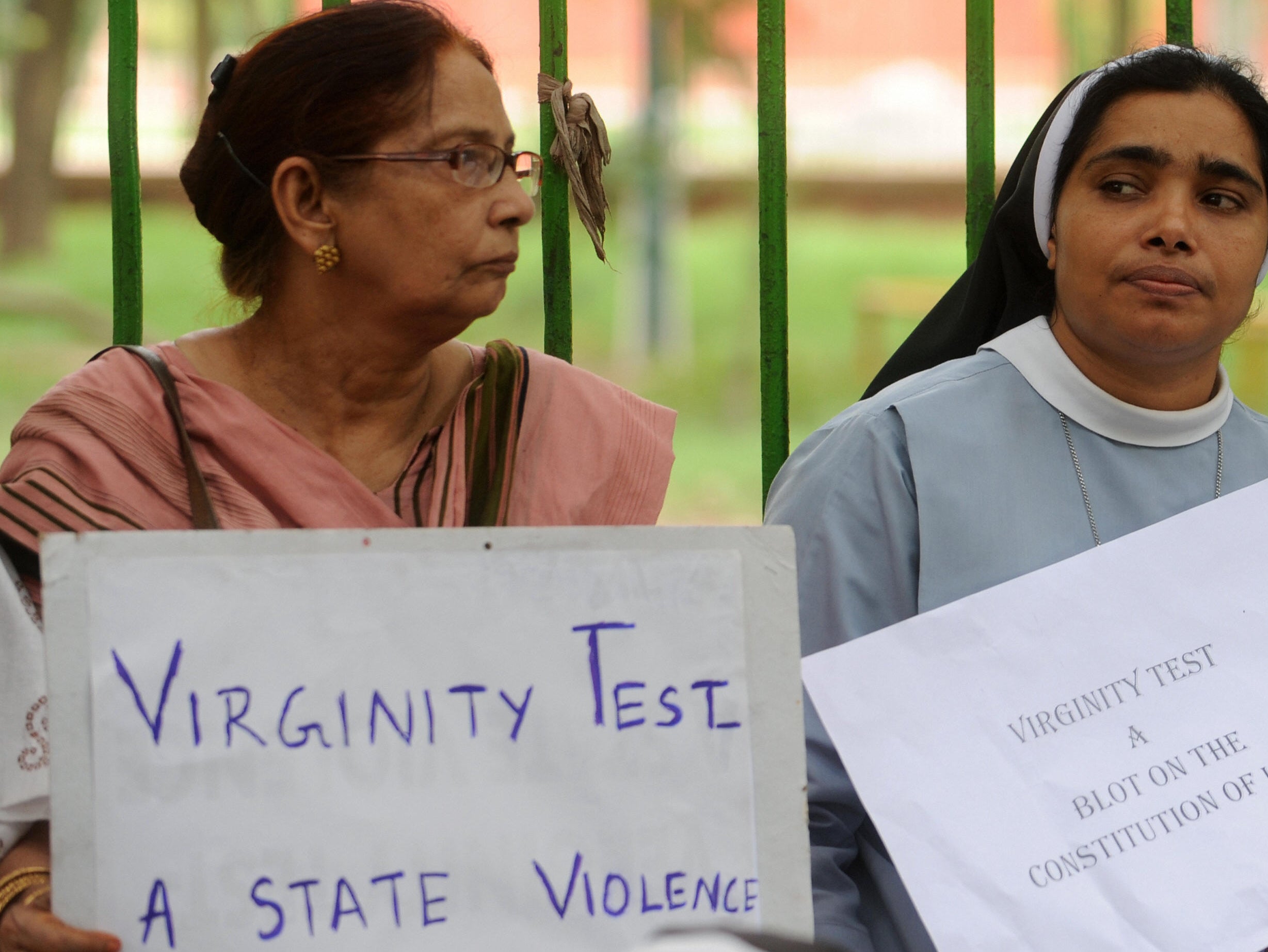 File image: Activists hold placard to demand ban on virginity test