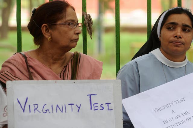 <p>File image: Activists hold placard to demand ban on virginity test</p>