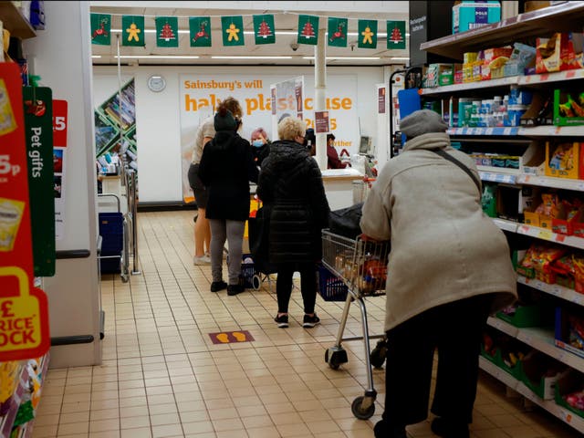 Shoppers queue to pay for their goods at a Sainsbury’s check-out desk on 22 December
