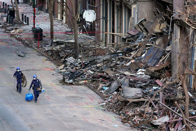 <p>FILE - In this Jan. 4, 2021, file photo, police officers walk past damaged buildings in Nashville, Tenn.  </p>