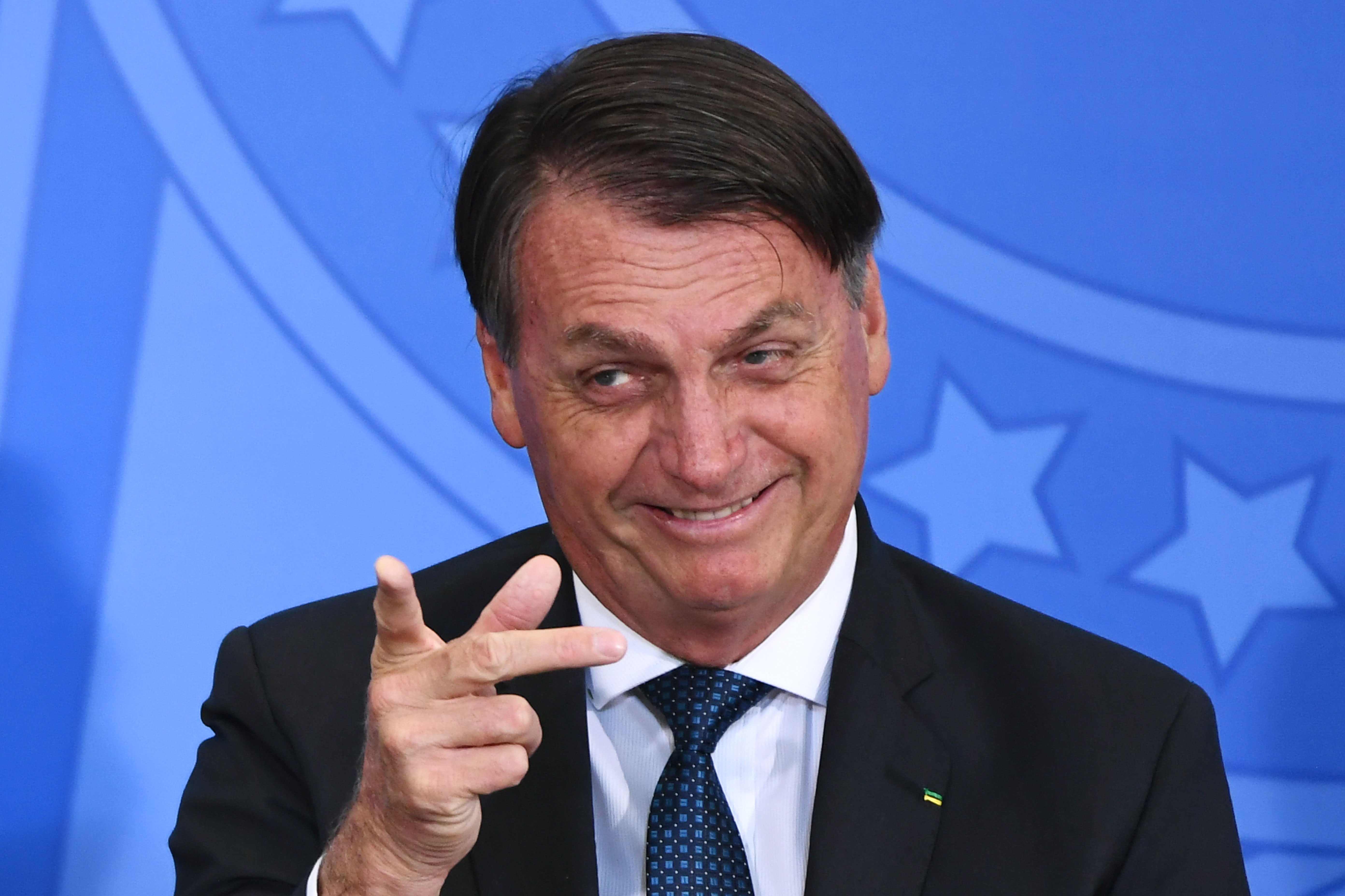 Brazilian President Jair Bolsonaro gestures during the inauguration ceremony of his new Tourism Minister Gilson Machado (not depicted) at Planalto Palace in Brasilia, on December 17, 2020. Mr Bolsonaro has suggested that the best vaccine for coronavirus is contracting coronavirus.