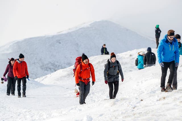 People walk through the snow on Mam Tor in the Peak District, Derbyshire, on 3 January, 2021. 