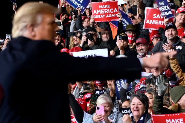 <p>Supporters cheer as Trump gestures after speaking during a rally to support Republican Senate candidates at Valdosta Regional Airport in Valdosta, Georgia on 5 December 2020.</p>