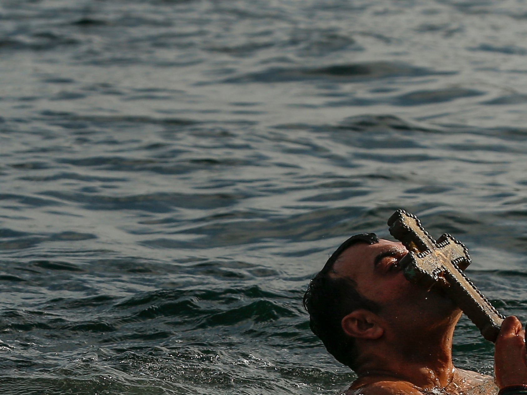 Orthodox Christian Vasili Kurkcu kisses the crucifix he fetched out the water in Turkey