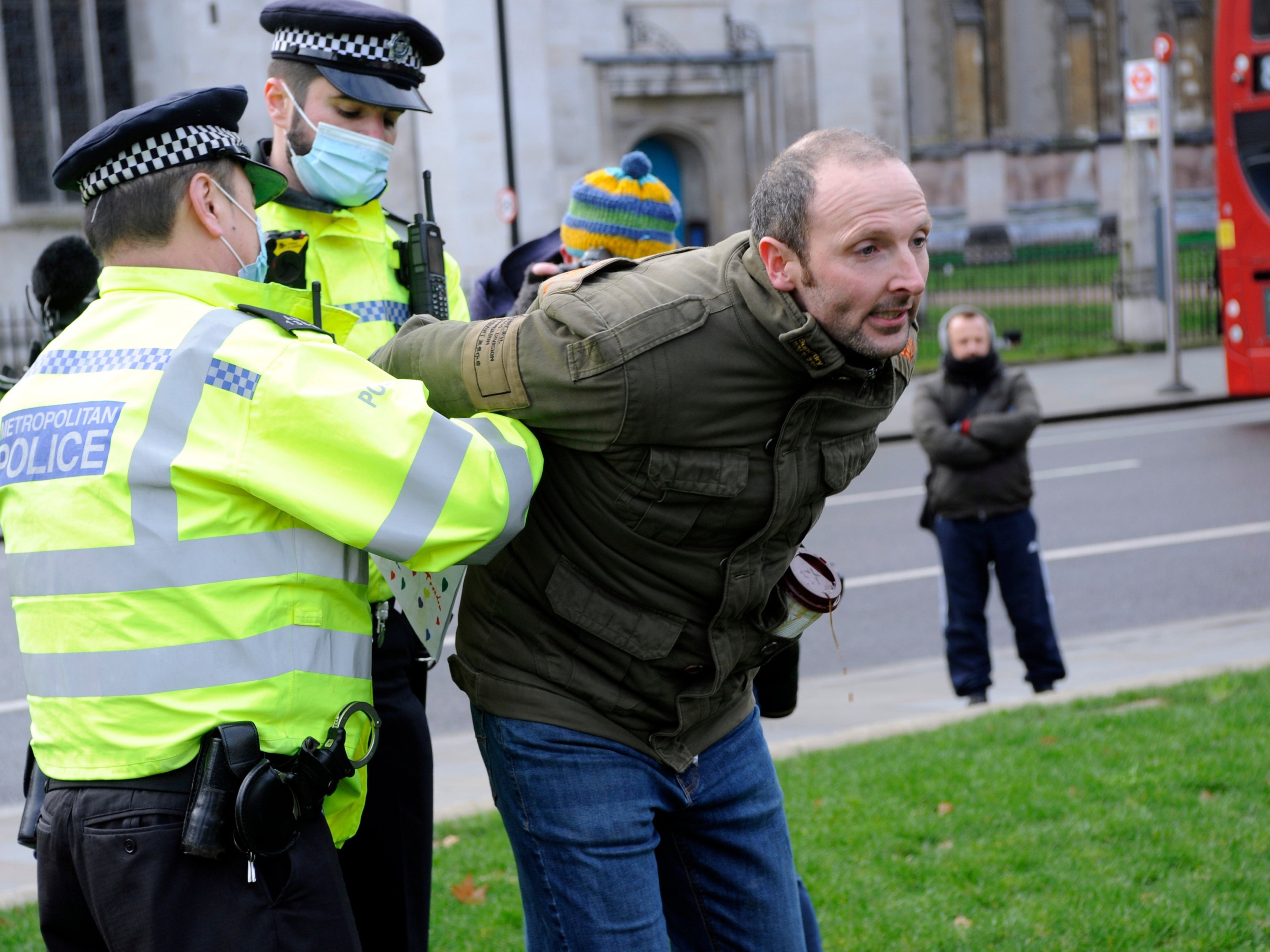 A demonstrator is apprehended at an anti-lockdown protest in central London