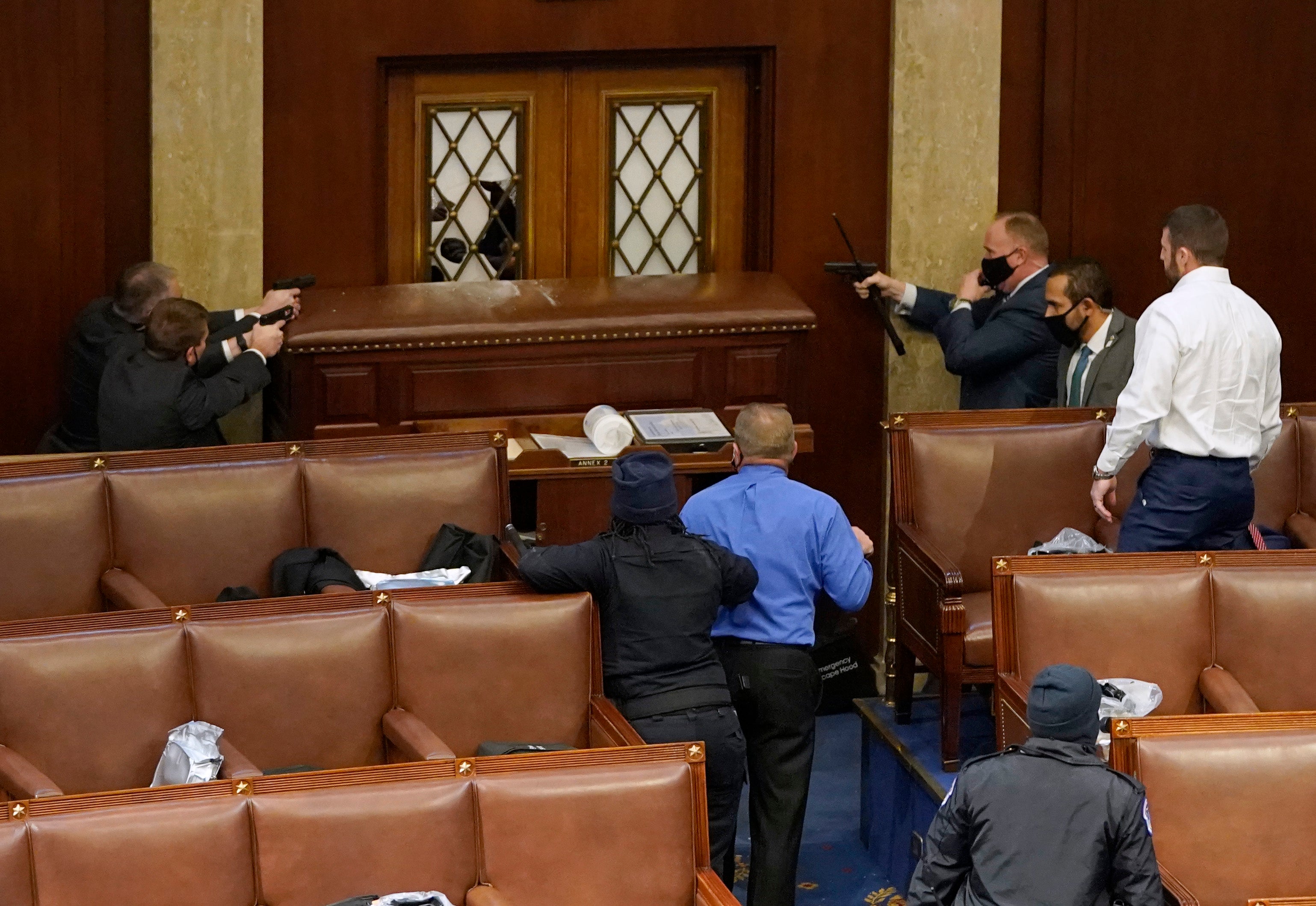 <p>Security officers hold rioters at bay inside the House chamber.</p>