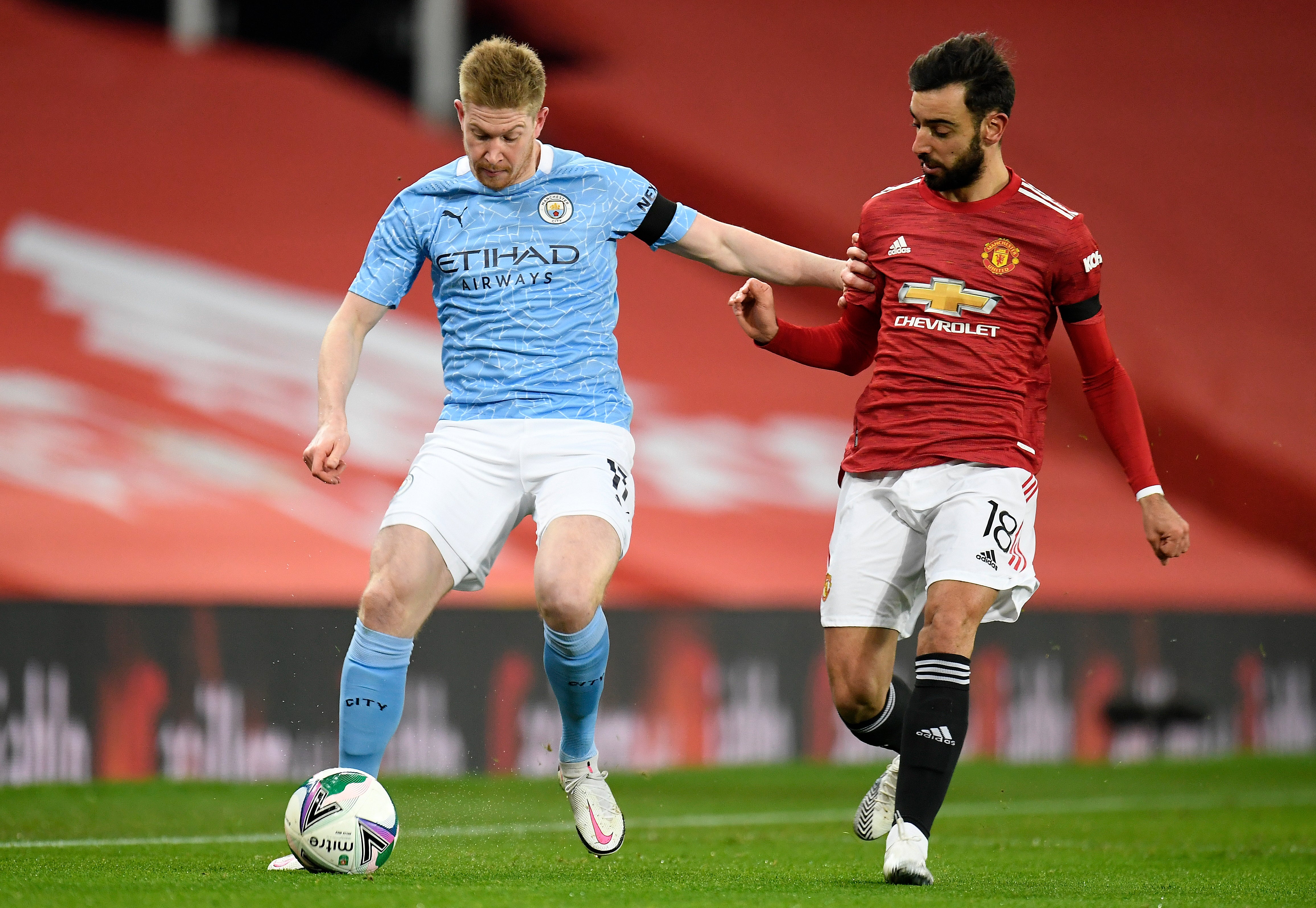 Bruno Fernandes (right) vies for the ball with Kevin De Bruyne