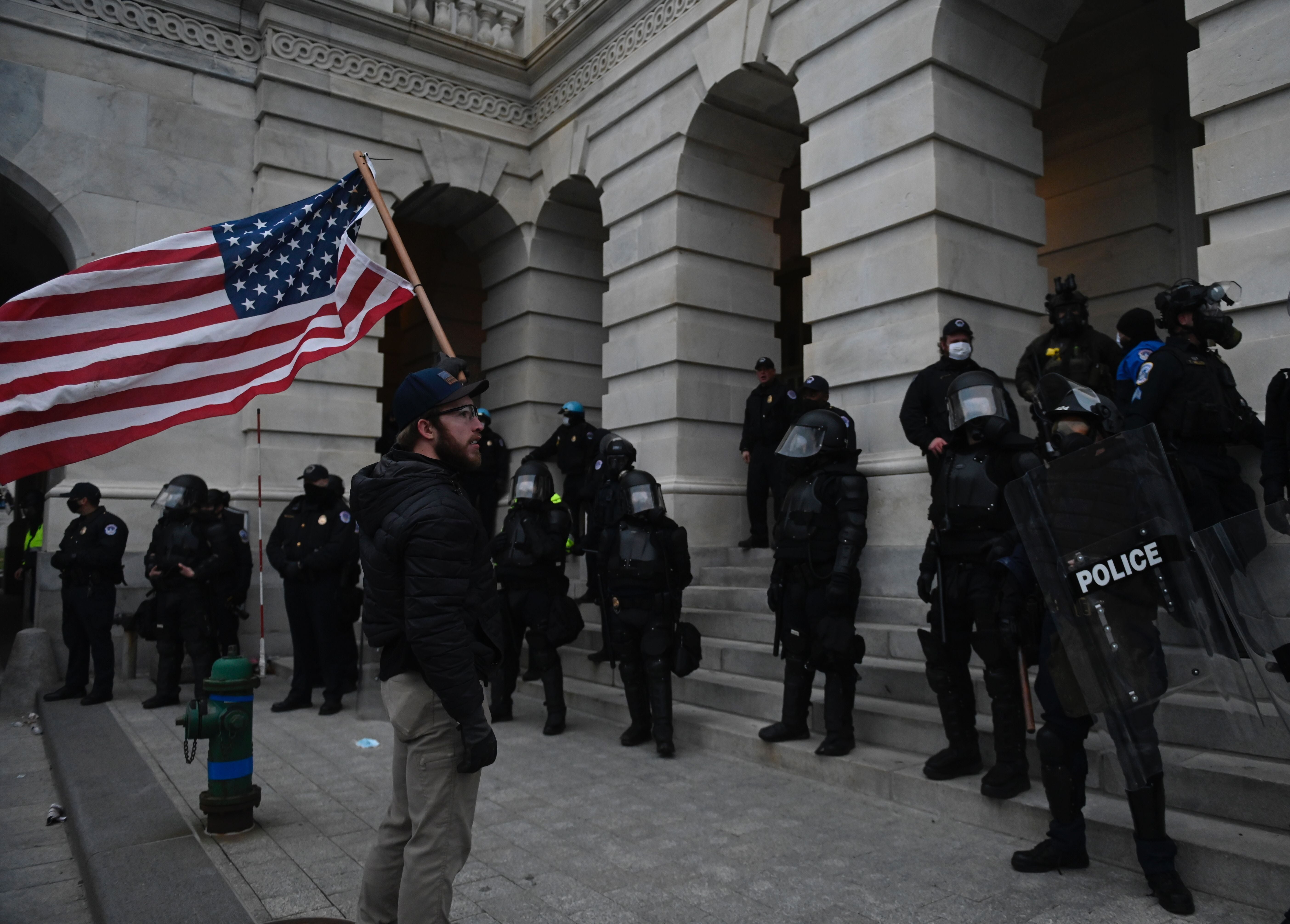 Police look on as a Trump supporter approaches the US Capitol
