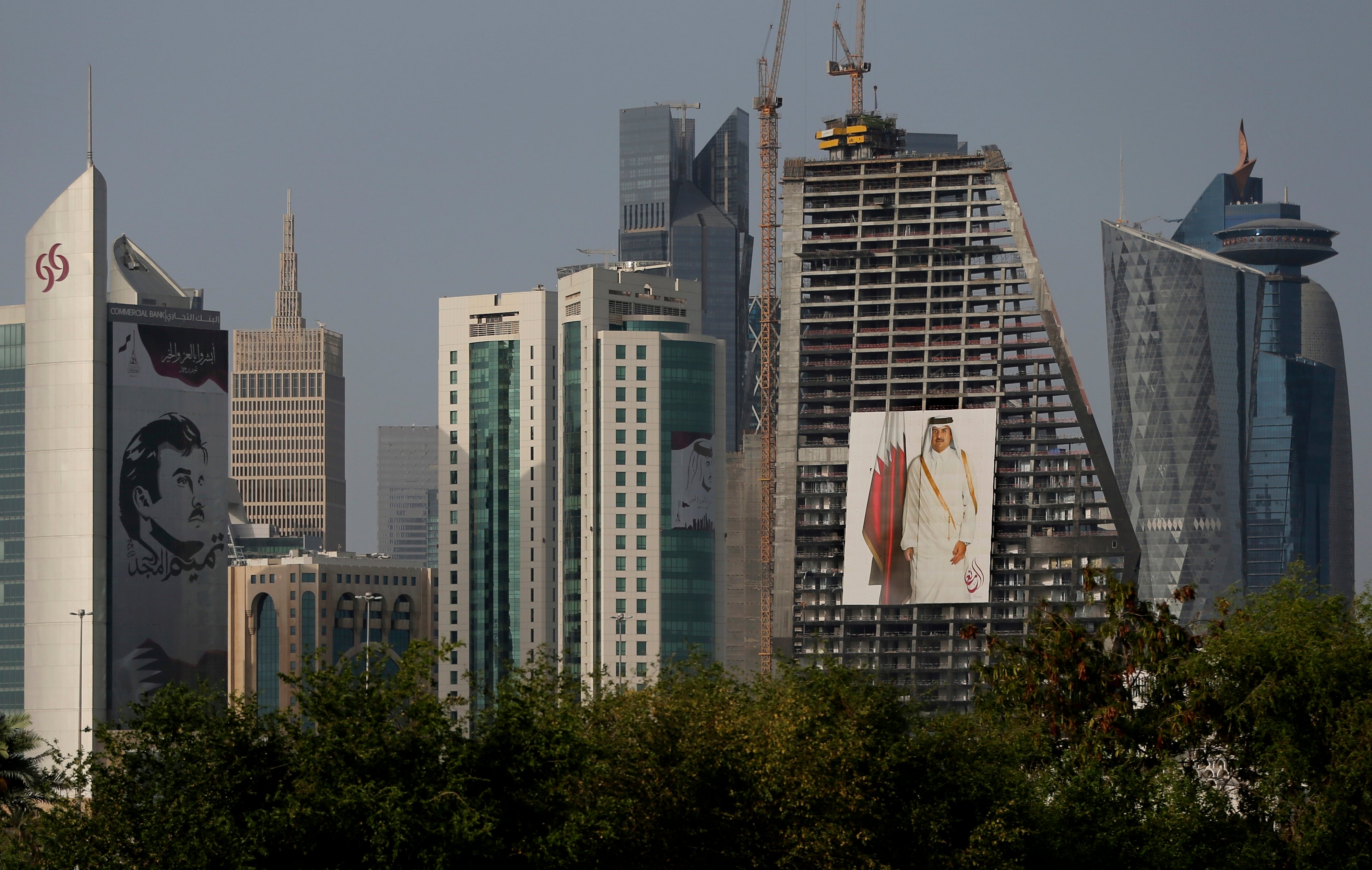 Images of the Emir of Qatar hang on towers in Doha