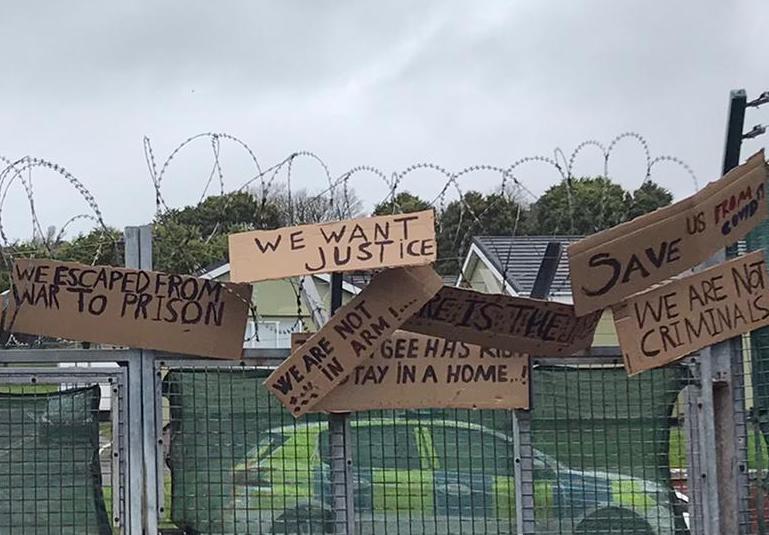Protest signs put up by asylum seekers housed at the Penally military camp last month call for ‘justice’ and aid.