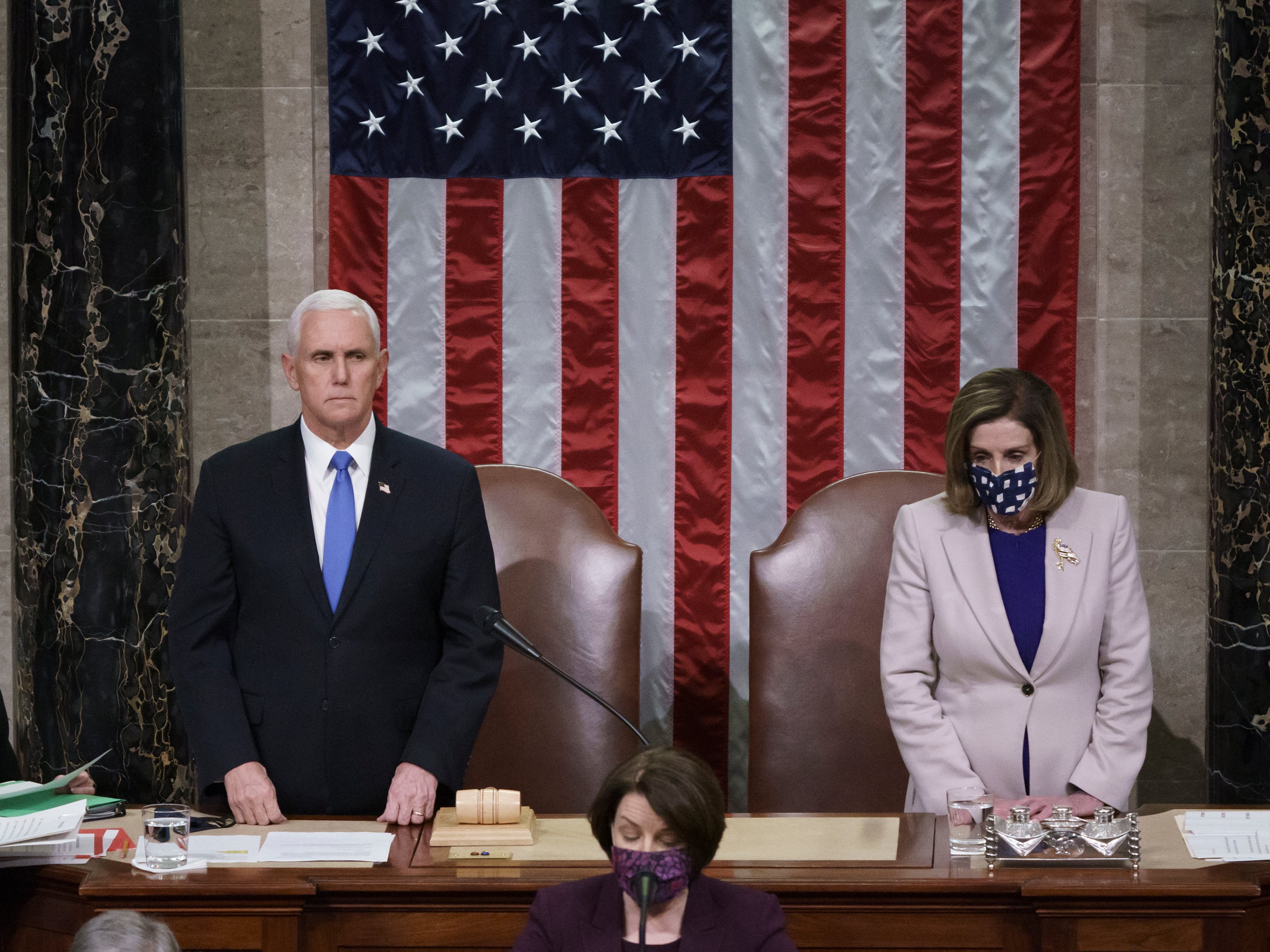 Vice President Mike Pence and Speaker of the House Nancy Pelosi read the final certification of Electoral College votes cast in November’s presidential election during a joint session of Congress, after working through the night, at the Capitol on 7 January 2021 in Washington, DC