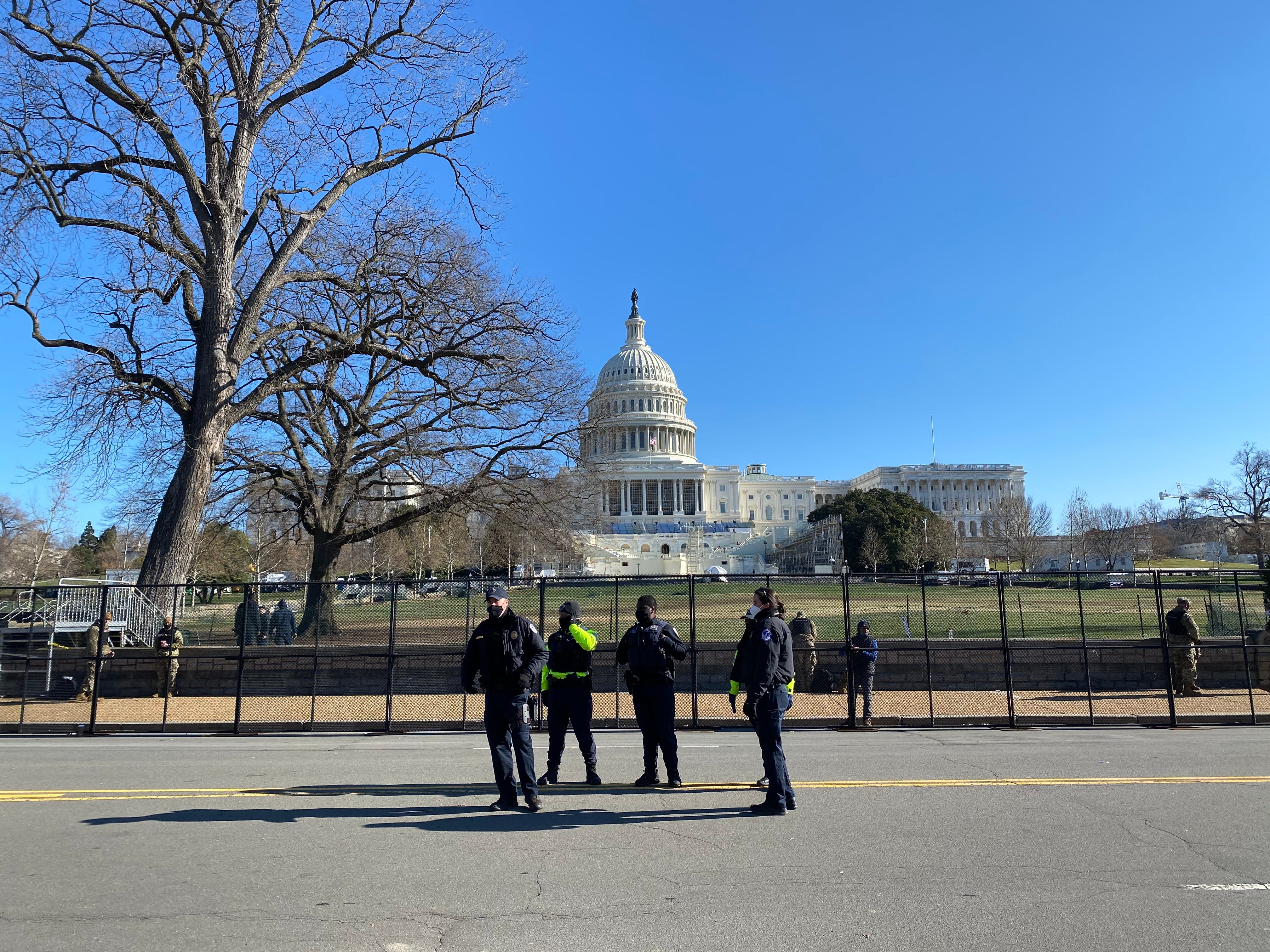 Police stand in front of a newly erected fence outside the US Capitol building a day after it was stormed by a mob of Trump supporters.&nbsp;