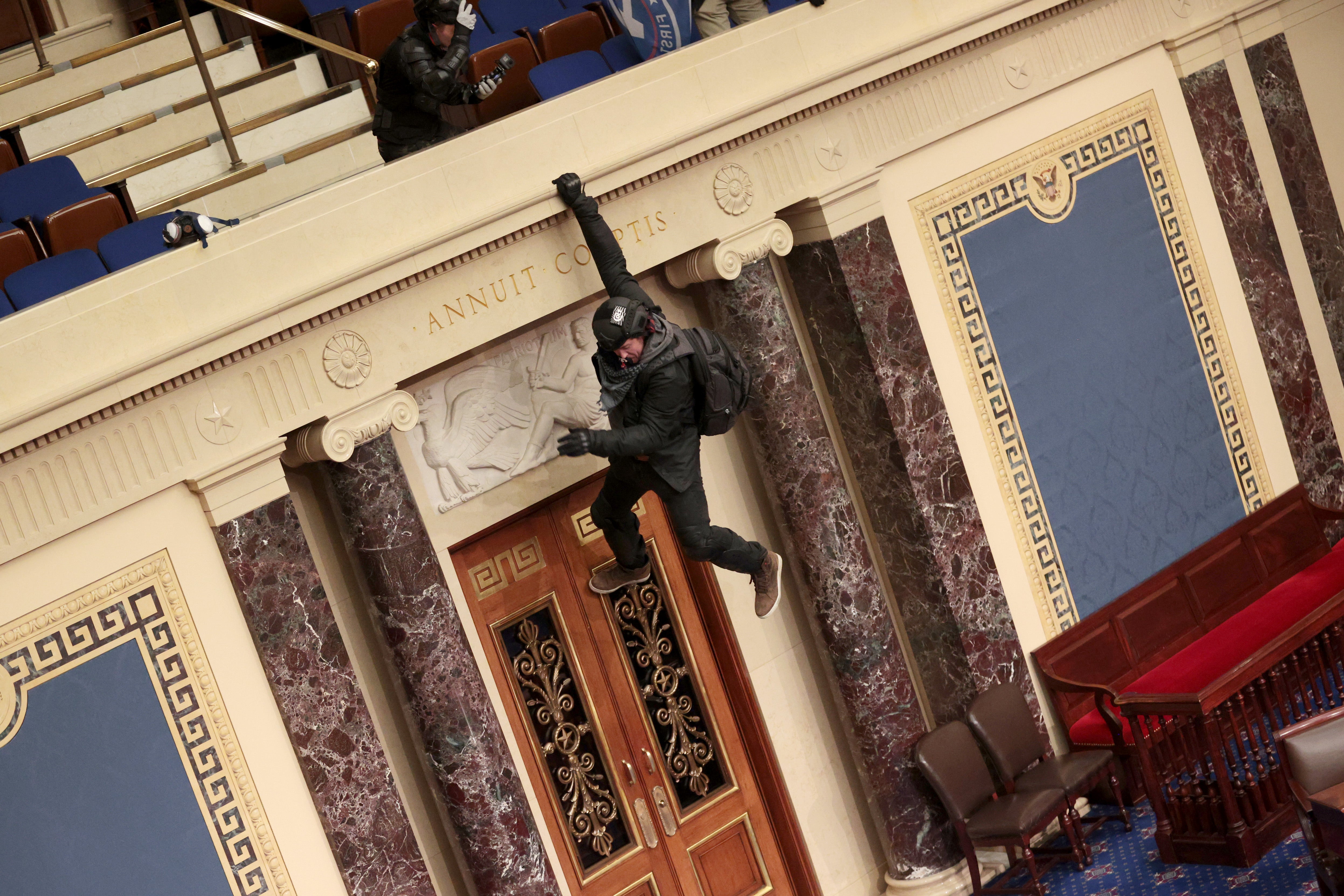 Protestor part of pro-Trump mob hanging from the balcony says he urged for calm