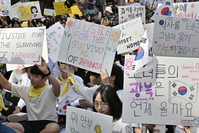 <p>File Image: Supporters of former ‘comfort women’, who were forced to serve as sex slaves for Japanese troops during World War II, hold placards during a demonstration demanding the Japanese government's formal apology near the Japanese embassy in Seoul on 18 September 2019</p>