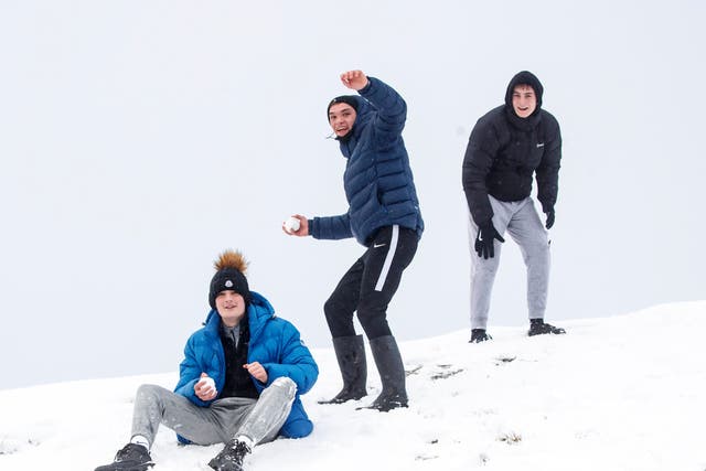 <p>People enjoy a snowball fight near Mam Tor in the Peak District, Derbyshire.</p>