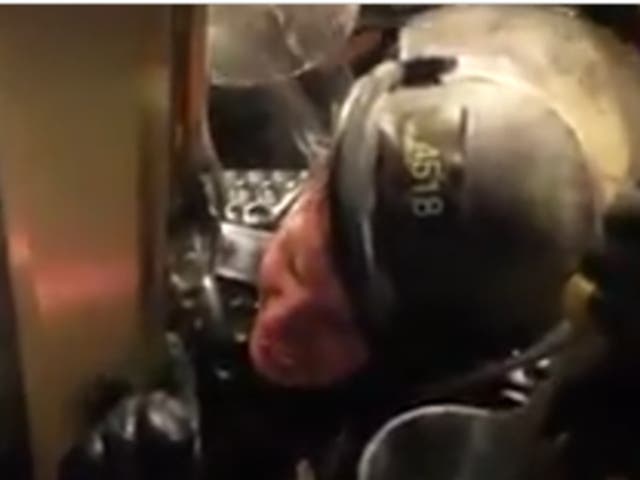 A US Capitol police officer is crushed between a door and a throng of Trump supporters during the US Capitol riot in Washington DC on 6 January.