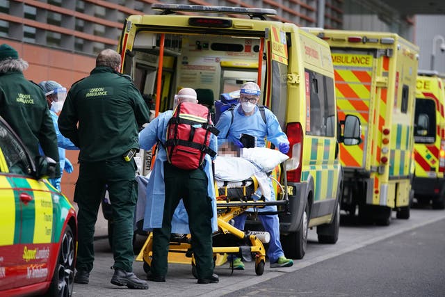 Paramedics transfer a patient from an ambulance into the Royal London Hospital
