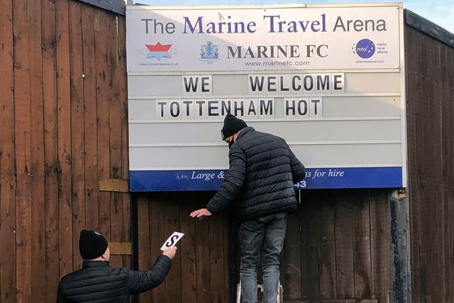 Volunteers hang up letters welcoming Tottenham Hotspur ahead of their FA Cup match