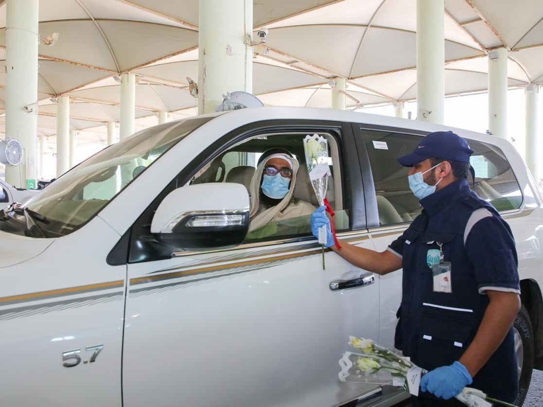 An officer gives flowers to a driver at a border crossing of Saudi Arabia with Qatar, after the two countries restored ties and opened borders