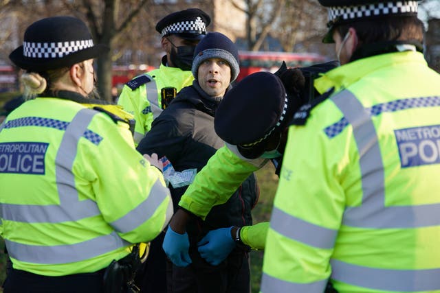 <p>Police detain a man during an anti-lockdown protest in Clapham Common, southwest London</p>