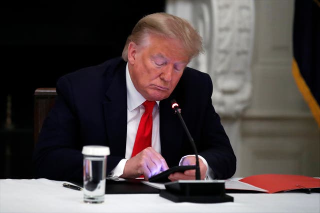 <p>ARCHIVO – En esta fotografía de archivo del jueves 18 de junio de 2020, el presidente Donald Trump utiliza su teléfono celular durante una mesa redonda con gobernadores para analizar la reapertura de pequeños negocios en Estados Unidos, en el comedor de la Casa Blanca, en Washington.&nbsp;</p>