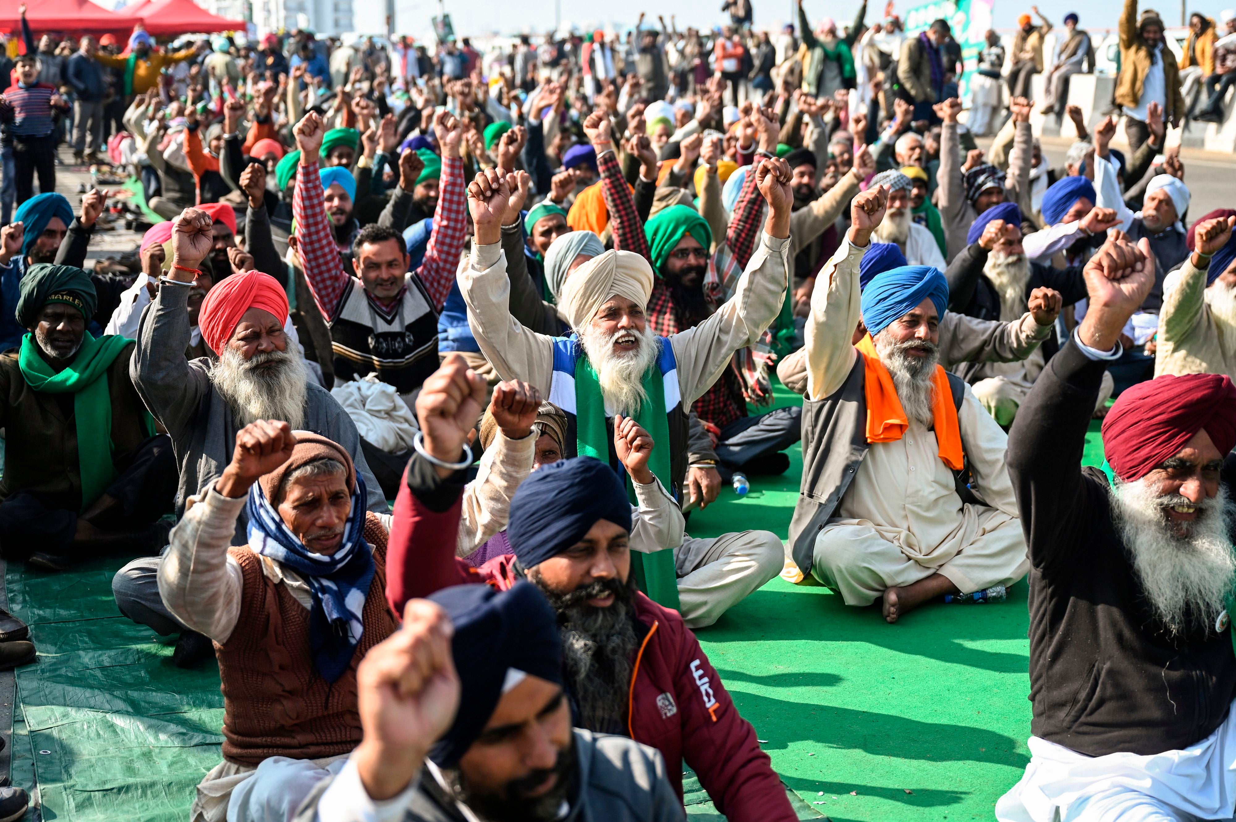 Protesting farmers shout slogans as they sit along a blocked highway during a protest against the central government's recent agricultural reforms at the Ghazipur Delhi-Uttar Pradesh state border in New Delhi on 11 January, 2021