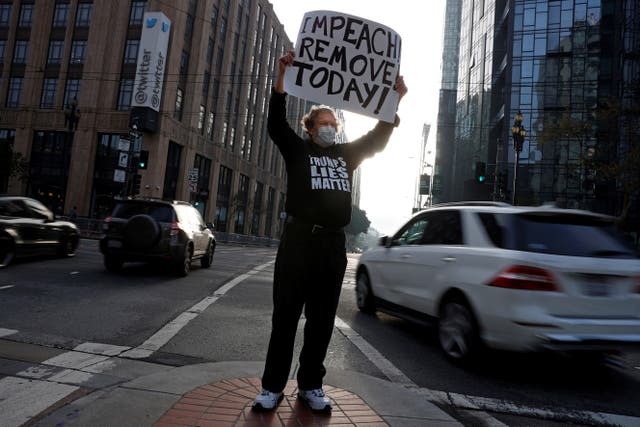<p>Kenneth Lundgreen holds a sign in counter-protest during what was supposed to be a pro-Trump demonstration outside Twitter headquarters in San Francisco</p>