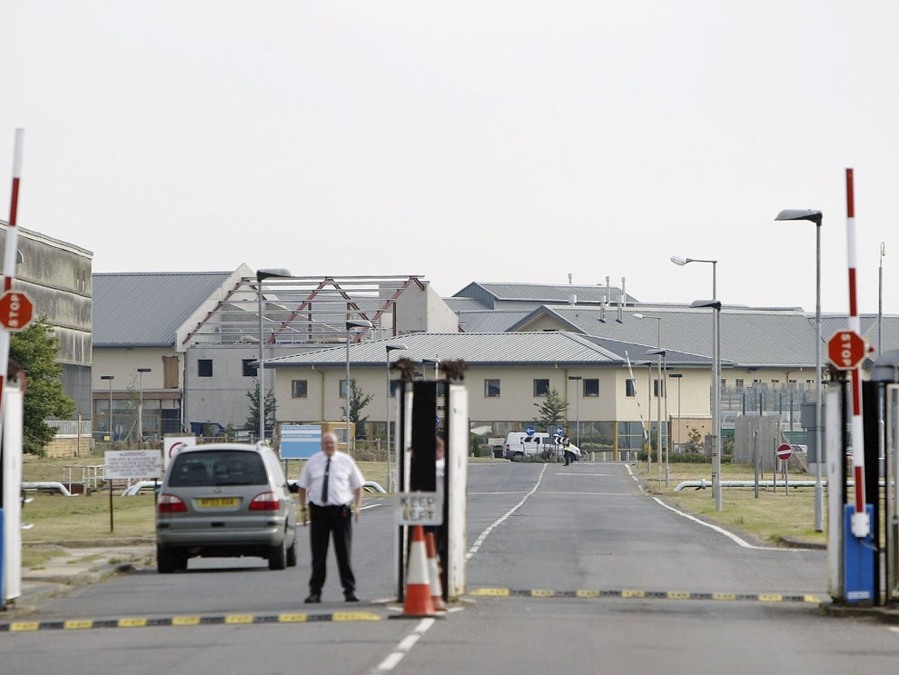 A security guard stands at the gates of the The Yarl’s Wood Immigration Center on September 2, 2003 in Bedford, England